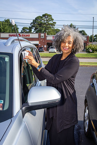 A community member mounts the temperature sensor to a car.